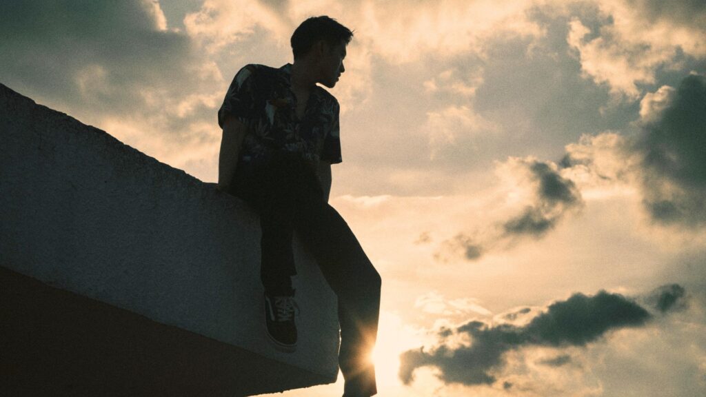 Joven relajado mirando el horizonte simbolizando tranquilidad financiera.